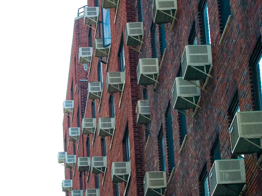Façade d'immeuble couverte de climatiseurs individuels