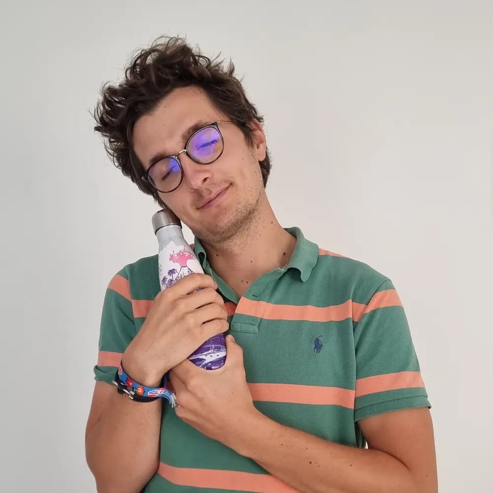 Stanislas serre sa gourde isotherme en inox contre sa joue, les yeux fermés