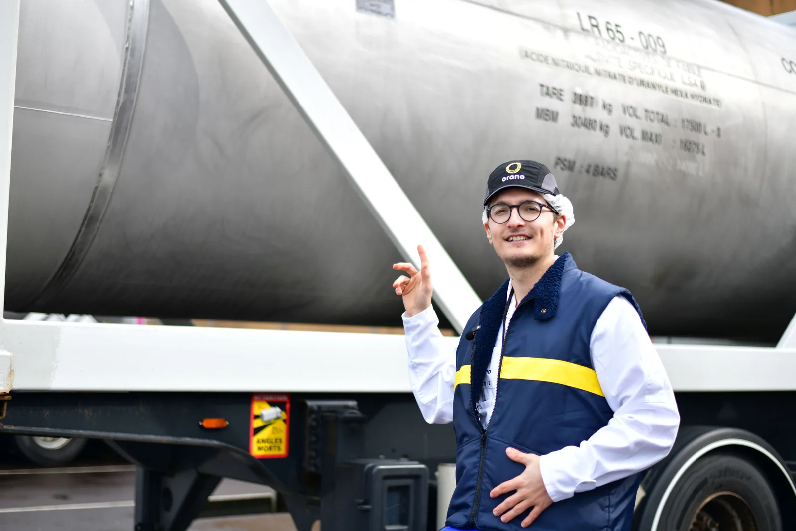 Moi devant une citerne routière de transport de nitrate d'uranyle, dont on lit le marquage sur la robe