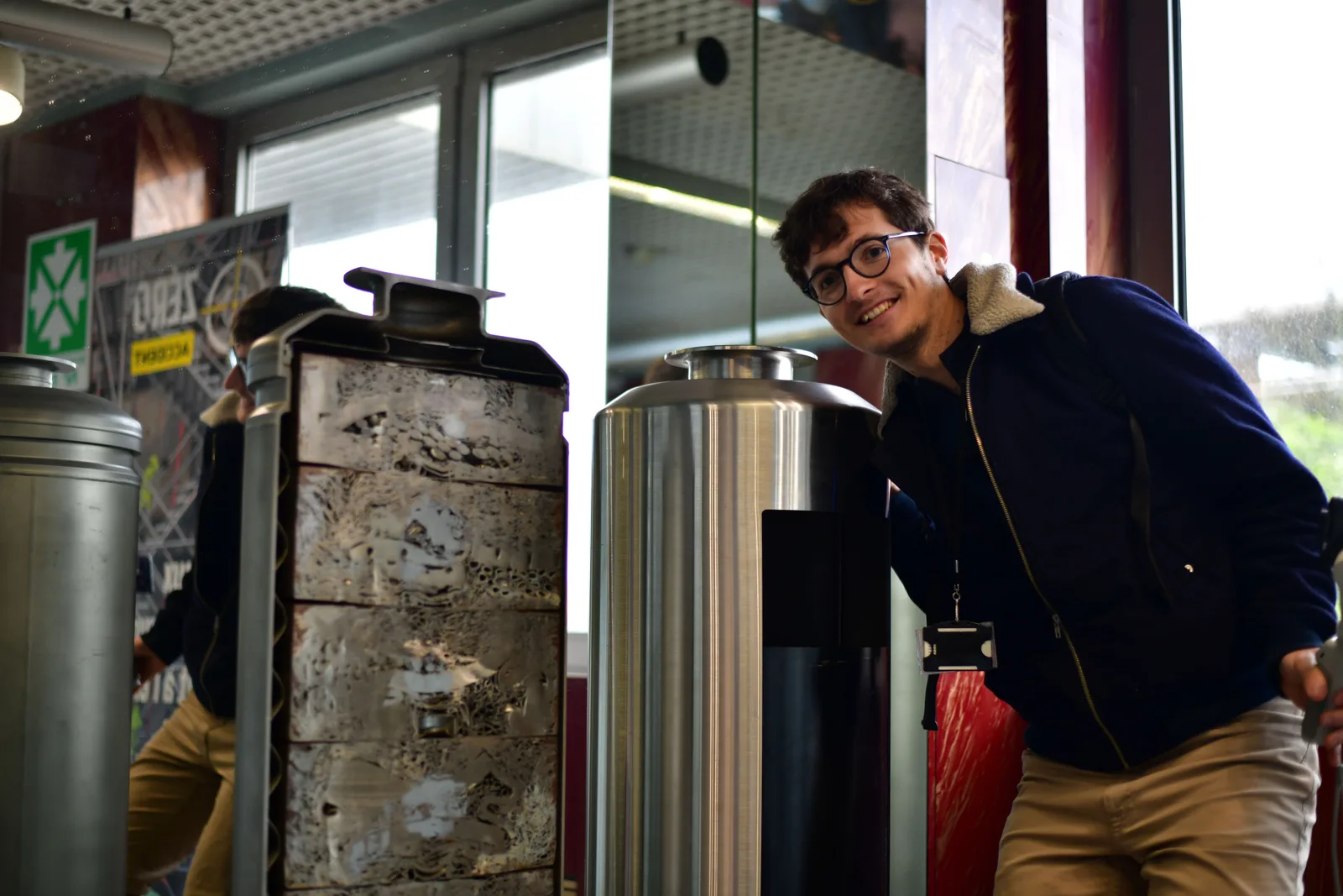 Moi entre une maquette de CSD-C ouverte, montrant les galettes de coques et embouts compactés, et un CSD-V factice en acier inoxydable