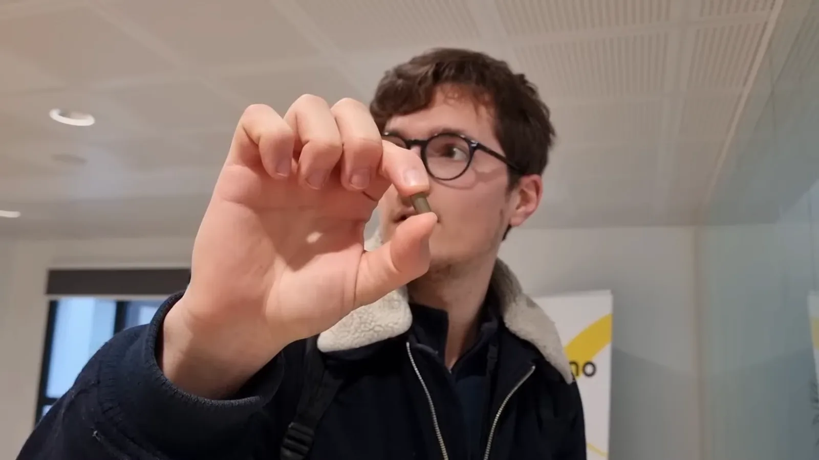 Moi tenant une pastille de combustible entre le pouce et l'index, lors de la visite d'Orano La Hague