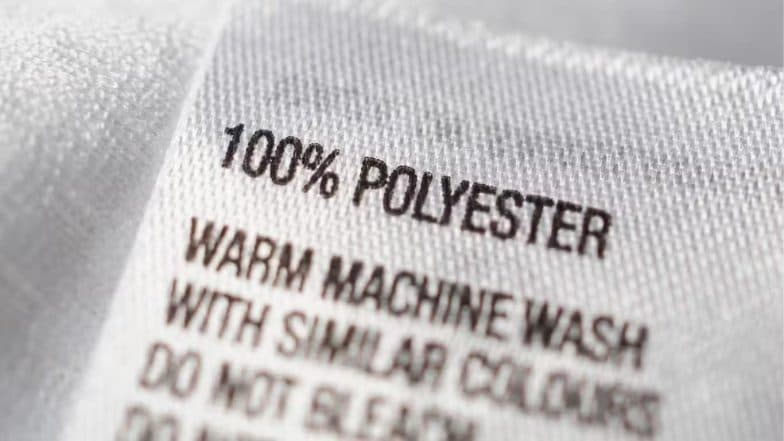Étiquette de vêtement en gros plan portant la mention « 100% POLYESTER ».